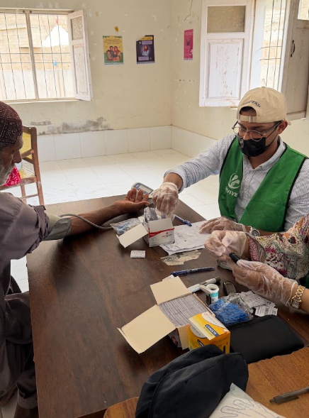 Checking a patient's blood pressure at a Revive medical camp